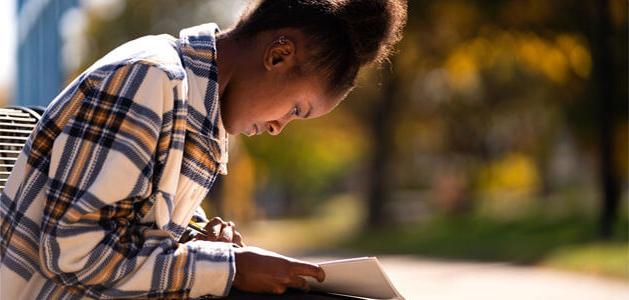 Woman sitting on bench while reading